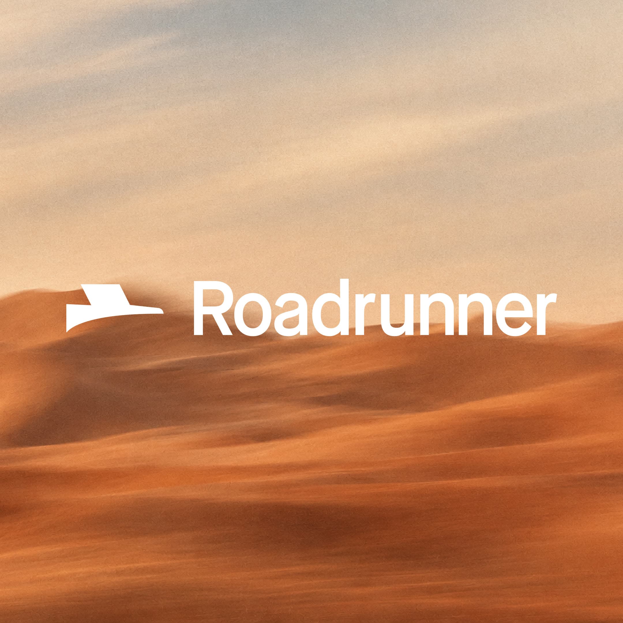 The Roadrunner logo over desert sand dunes at dusk